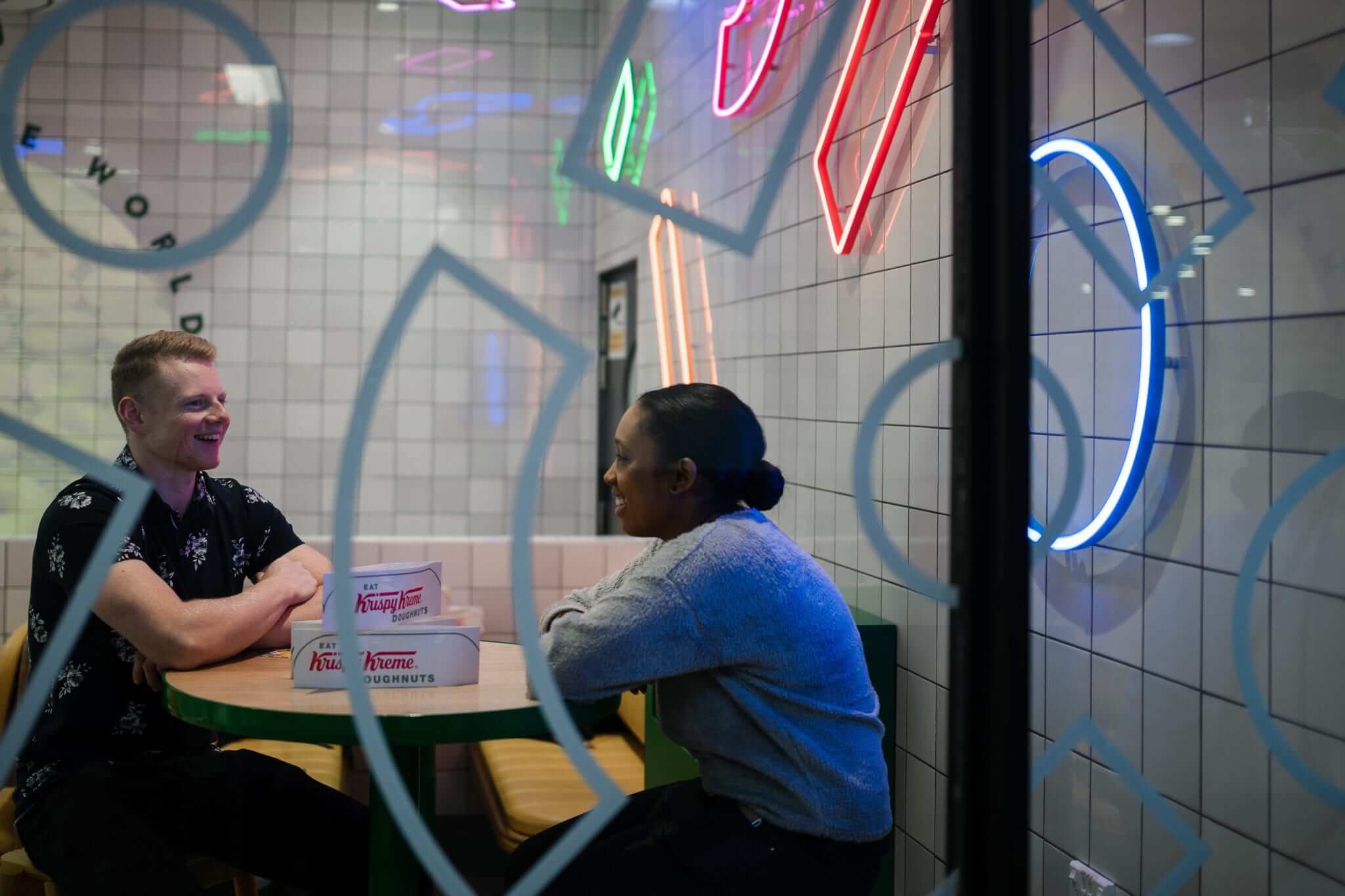 two friends hanging out in 80s themed cafe