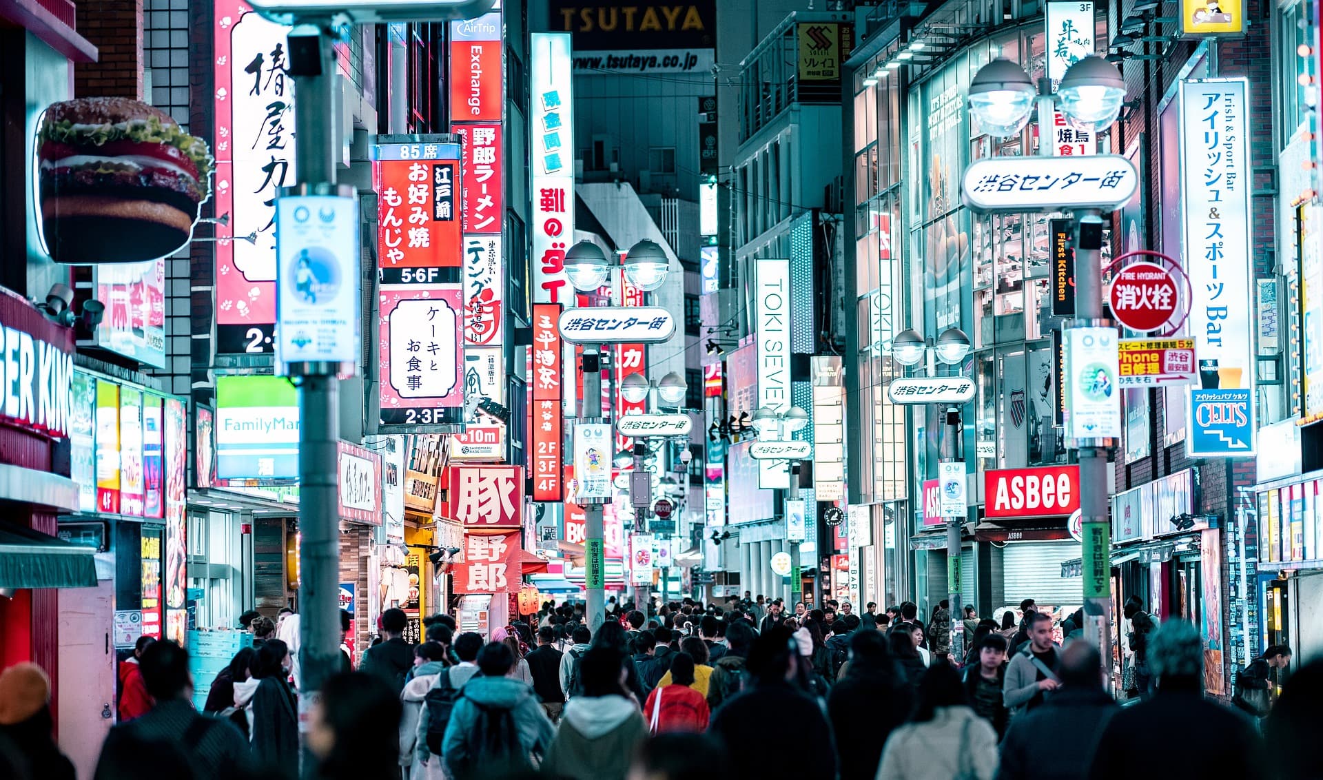 crowded street lit by neon signs in in Tokyo's Shibuya City in Japan