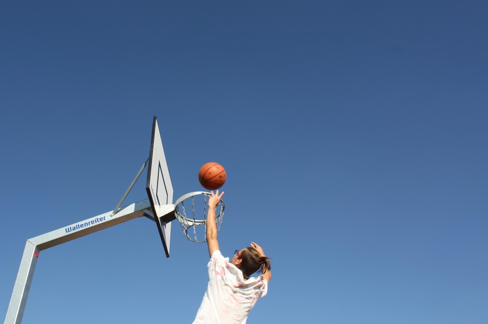 man sinking basket on outdoor basketball court