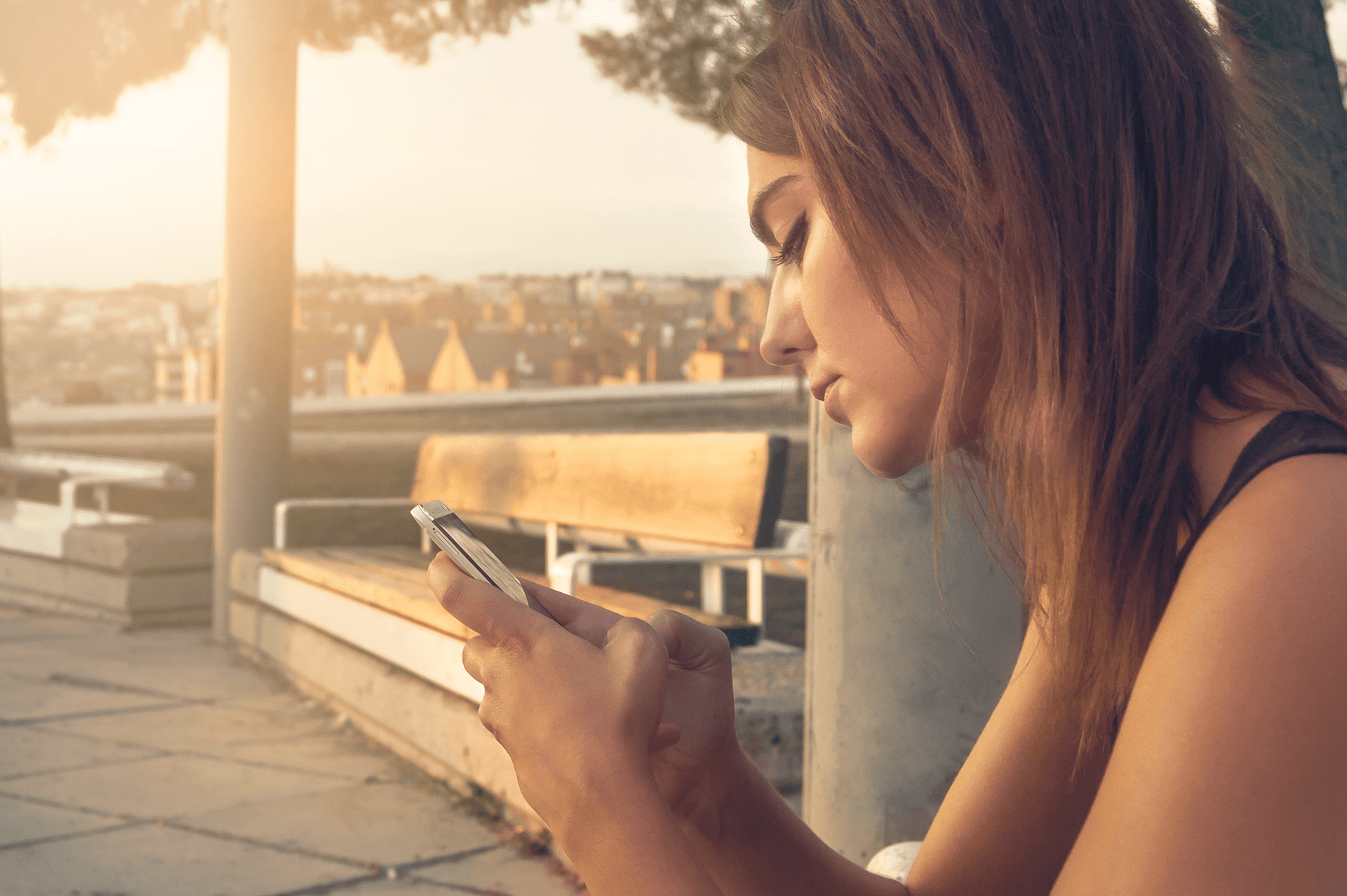 woman on phone outside on bench