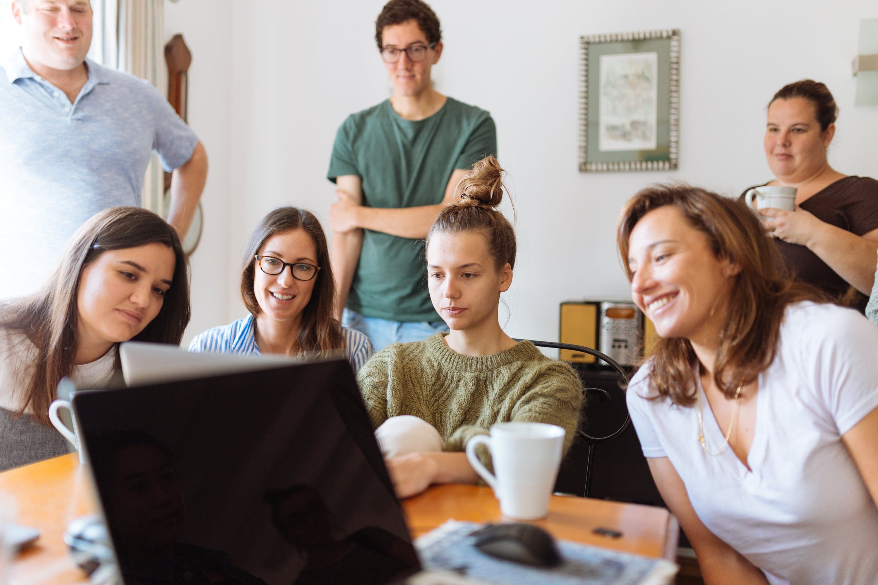 group of students looking at laptop computer