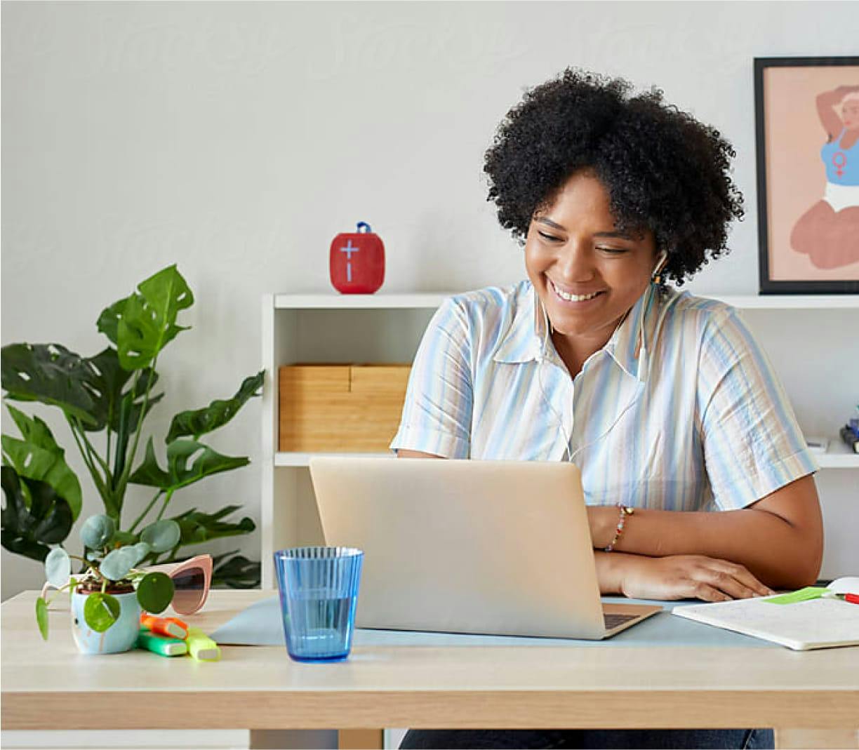 Smiling woman wearing earphones sitting at computer