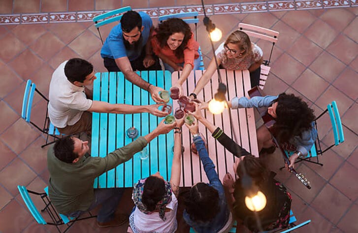 group of friends cheersing at a patio table