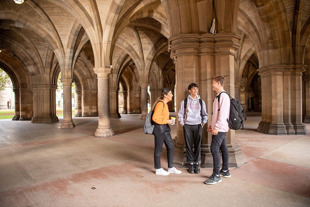 Group of students congregating under archways at the University of Glasgow