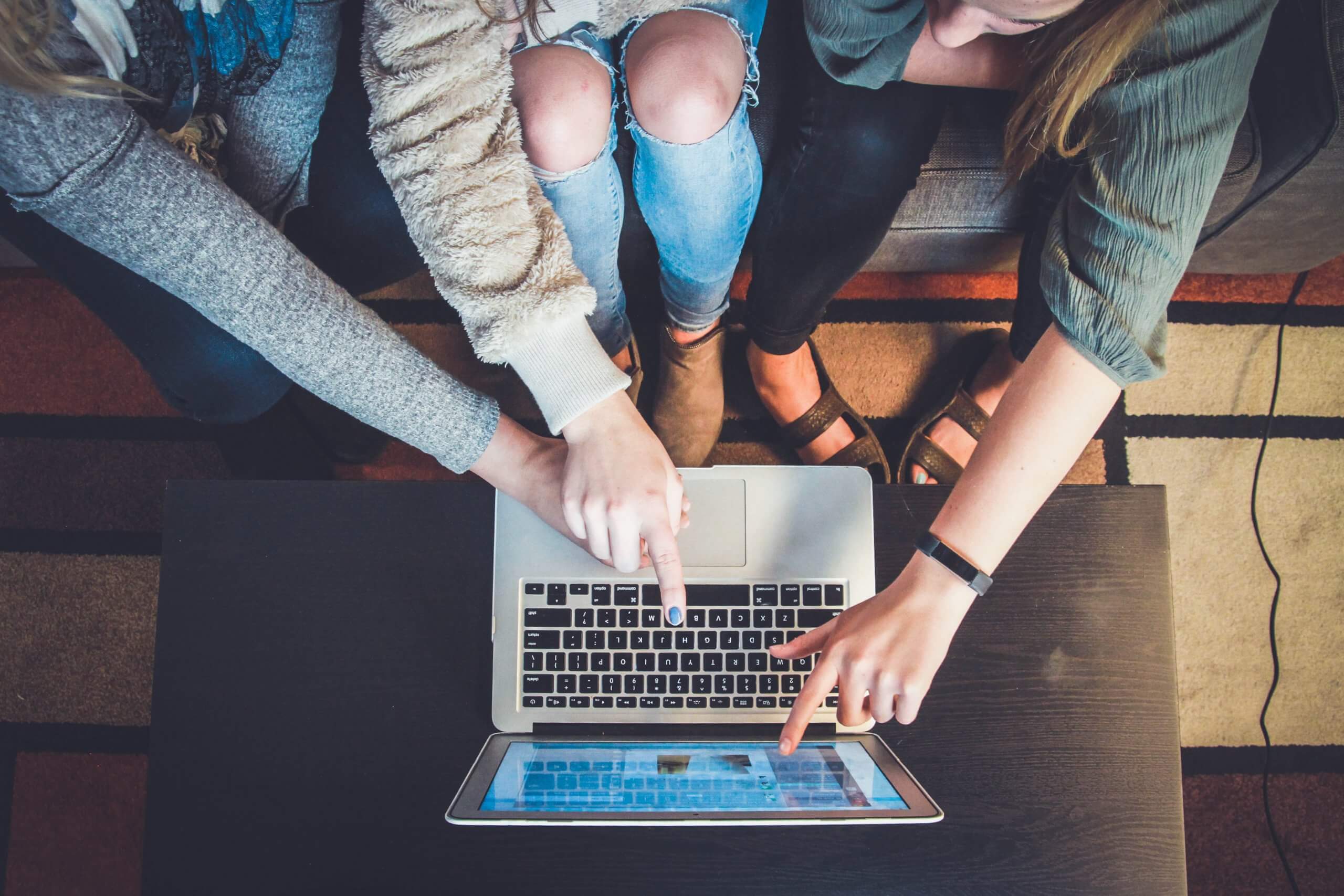 three people working off a single laptop